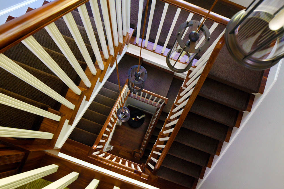Photo of an expansive transitional wood u-shaped staircase in New York with wood risers.