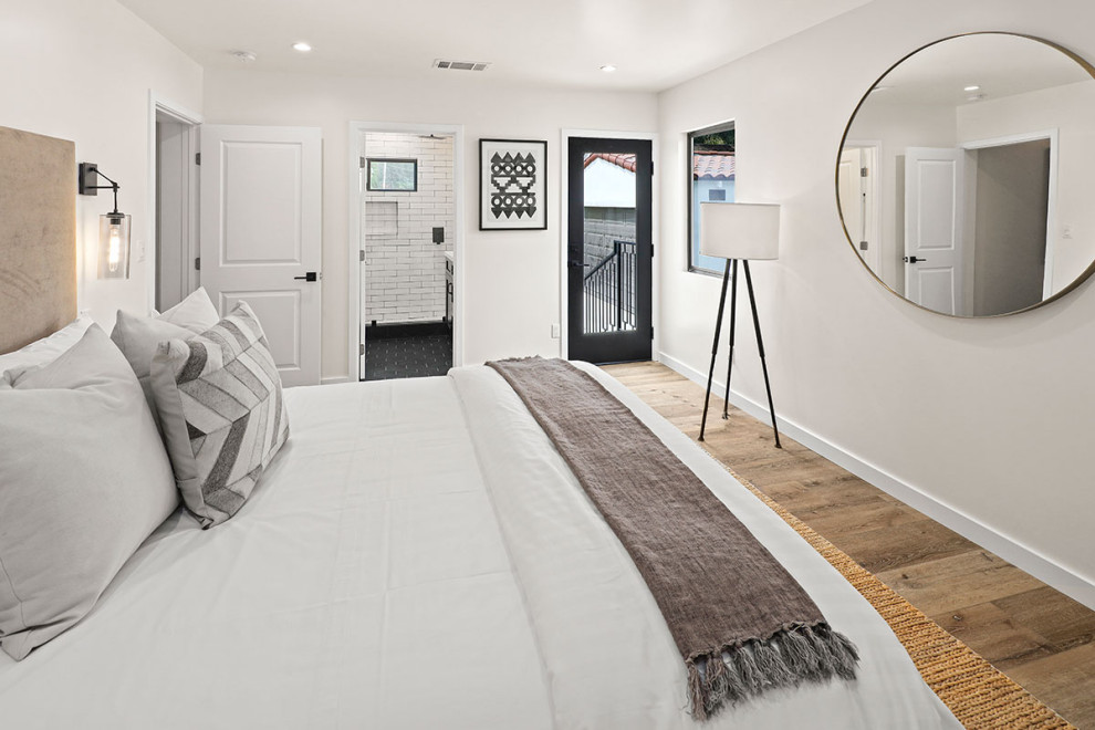 ロサンゼルスにある広いトランジショナルスタイルのおしゃれな主寝室 (白い壁、無垢フローリング、暖炉なし、茶色い床、白い天井) のインテリア