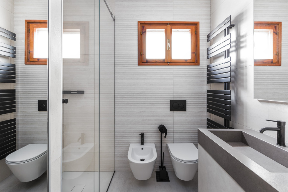 Design ideas for a small contemporary bathroom in Other with grey cabinets, a wall-mount toilet, beige tile, ceramic tile, beige walls, porcelain floors, an integrated sink, tile benchtops, beige floor, grey benchtops, a floating vanity and flat-panel cabinets.