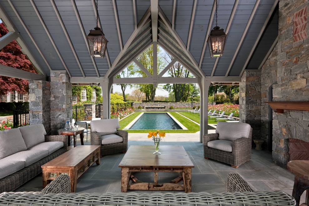 This is an example of a large traditional backyard patio in Philadelphia with natural stone pavers and a gazebo/cabana.