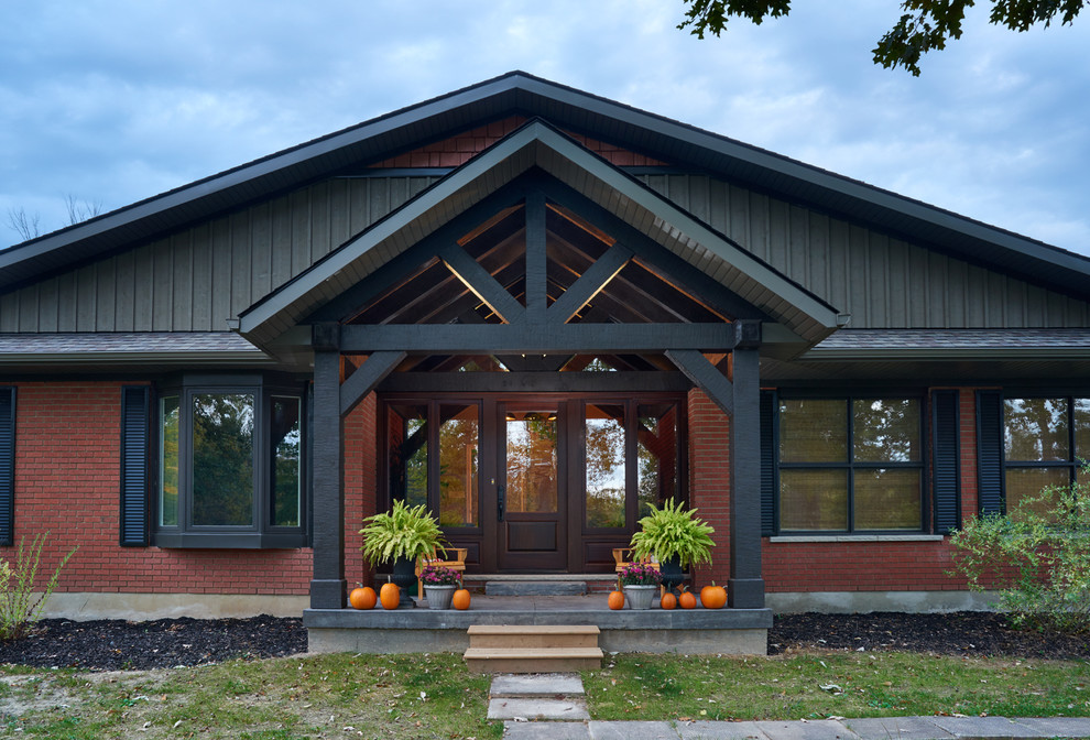 Inspiration for a mid-sized country split-level brick red exterior in Toronto with a gable roof.