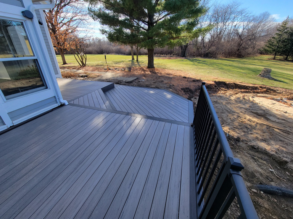 Mid-sized backyard ground level metal railing deck photo with no cover
