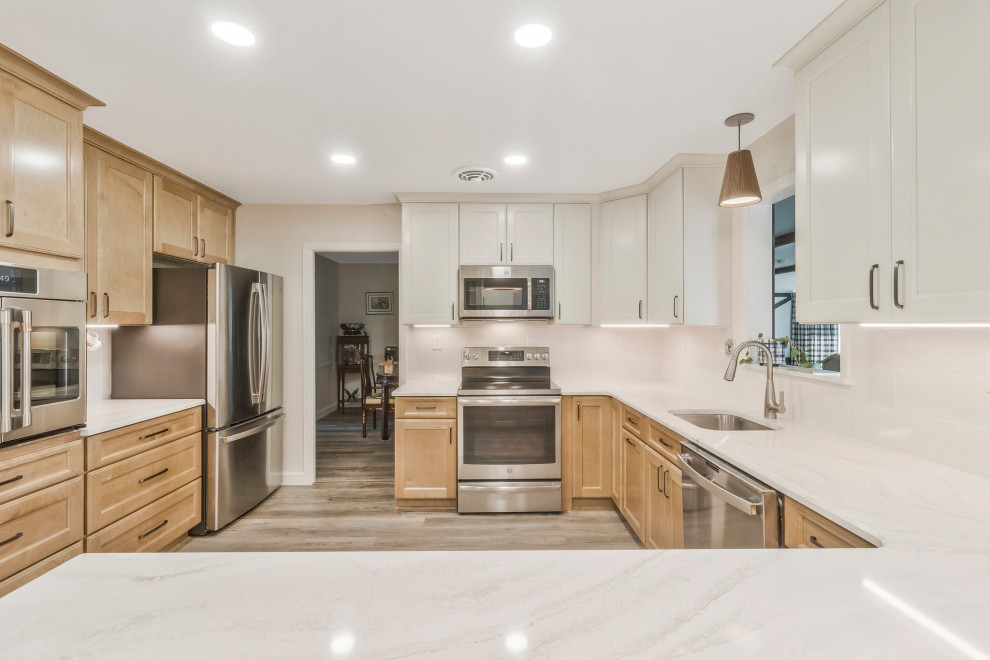 Huge transitional u-shaped kitchen pantry photo in DC Metro with an undermount sink, recessed-panel cabinets, quartz countertops, white backsplash, subway tile backsplash, stainless steel appliances, a peninsula and white countertops