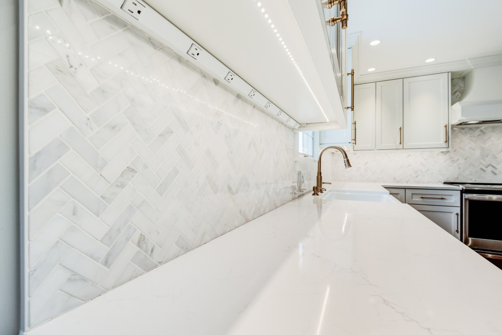 Eat-in kitchen - mid-sized transitional l-shaped light wood floor and brown floor eat-in kitchen idea in Chicago with a farmhouse sink, shaker cabinets, white cabinets, quartzite countertops, white backsplash, glass tile backsplash, colored appliances, an island and white countertops
