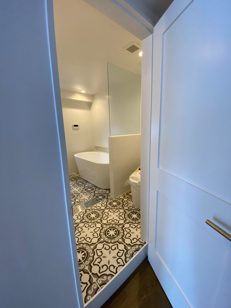 Design ideas for a mid-sized modern master bathroom in Tokyo with open cabinets, white cabinets, a freestanding tub, a corner shower, a one-piece toilet, white tile, subway tile, white walls, cement tiles, a vessel sink, limestone benchtops, multi-coloured floor, a hinged shower door, white benchtops, an enclosed toilet, a single vanity, a built-in vanity, timber and planked wall panelling.