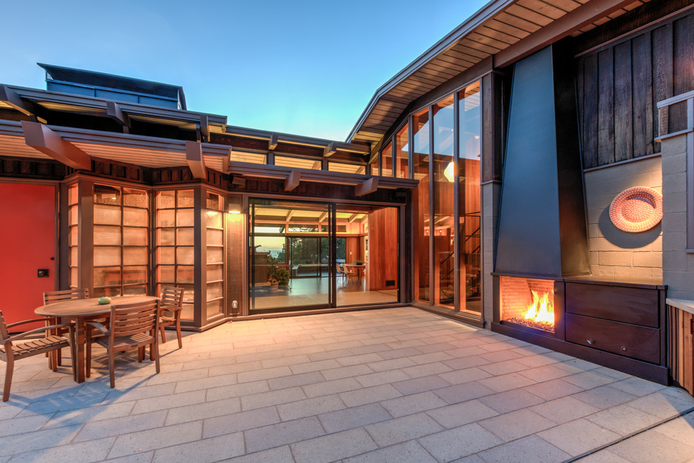 Example of a large 1950s backyard concrete paver patio design in San Francisco with a fireplace and no cover
