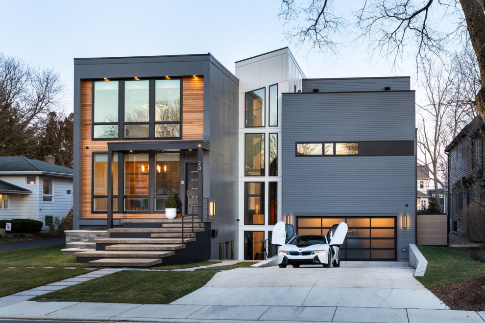 This is an example of a large modern two-storey grey house exterior with mixed siding, a shed roof and a metal roof.