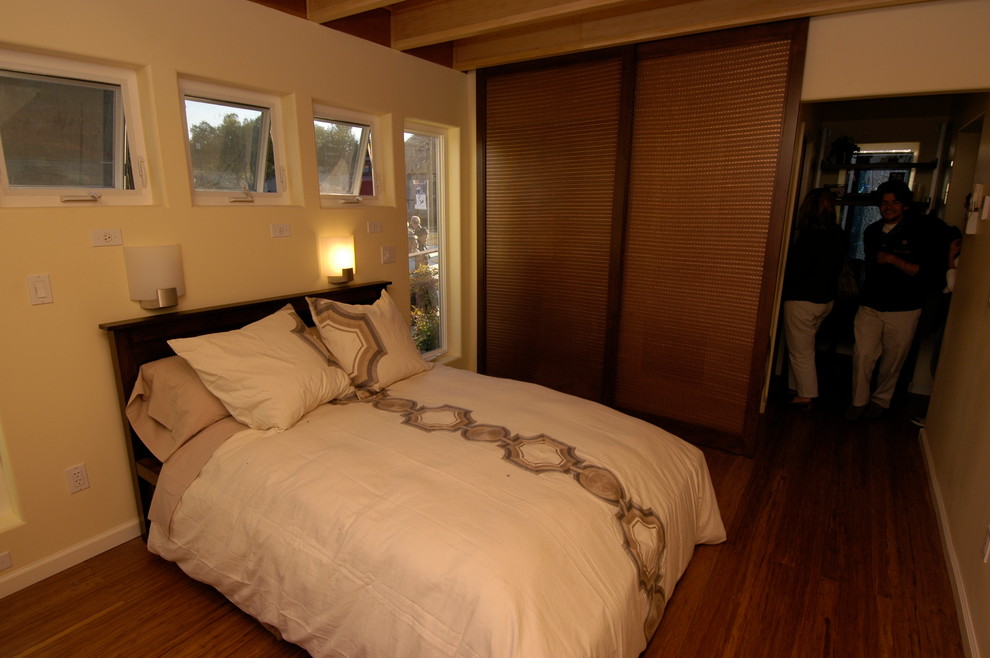 This is an example of a small contemporary guest bedroom in San Francisco with beige walls, medium hardwood floors and no fireplace.