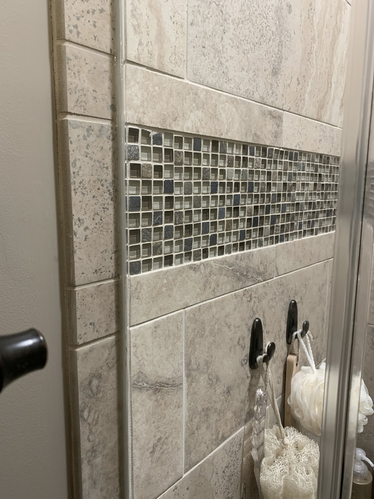 Example of a large transitional master beige tile and ceramic tile linoleum floor and brown floor home design design with recessed-panel cabinets, white cabinets, a two-piece toilet, beige walls, an undermount sink, granite countertops, a hinged shower door and multicolored countertops