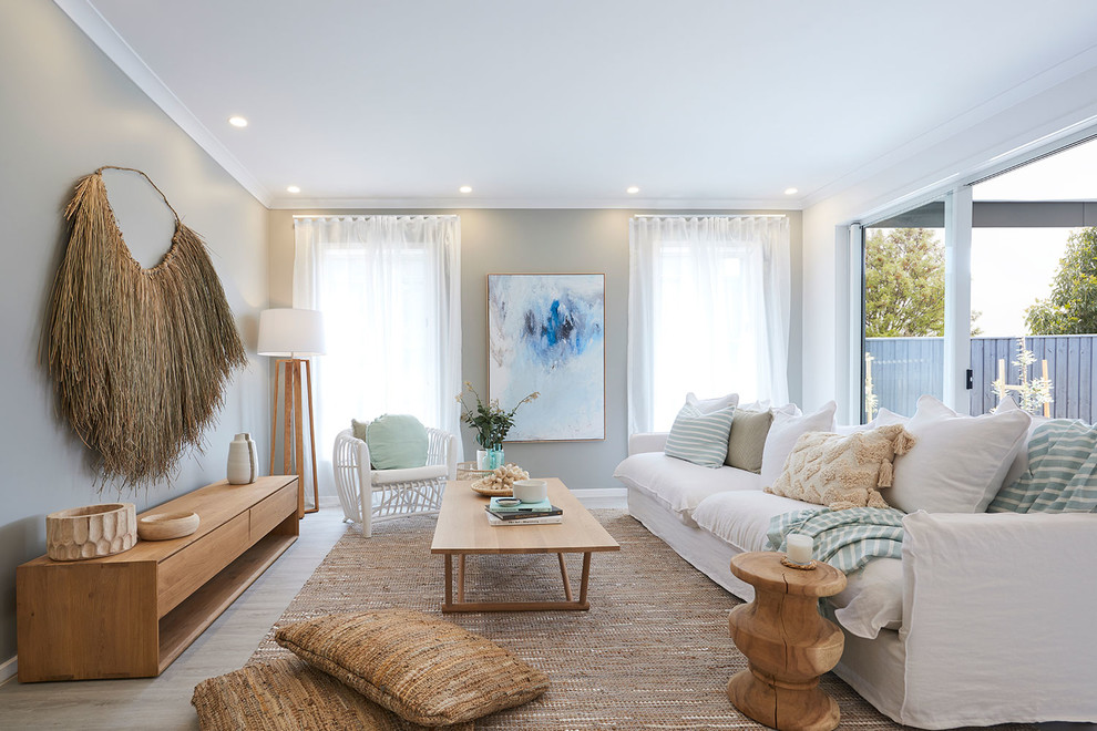 Design ideas for a beach style enclosed family room in Melbourne with beige walls, light hardwood floors and beige floor.