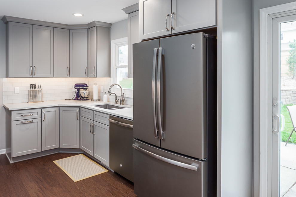 Eat-in kitchen - mid-sized transitional u-shaped laminate floor and brown floor eat-in kitchen idea with an undermount sink, recessed-panel cabinets, gray cabinets, quartzite countertops, white backsplash, subway tile backsplash, stainless steel appliances and no island