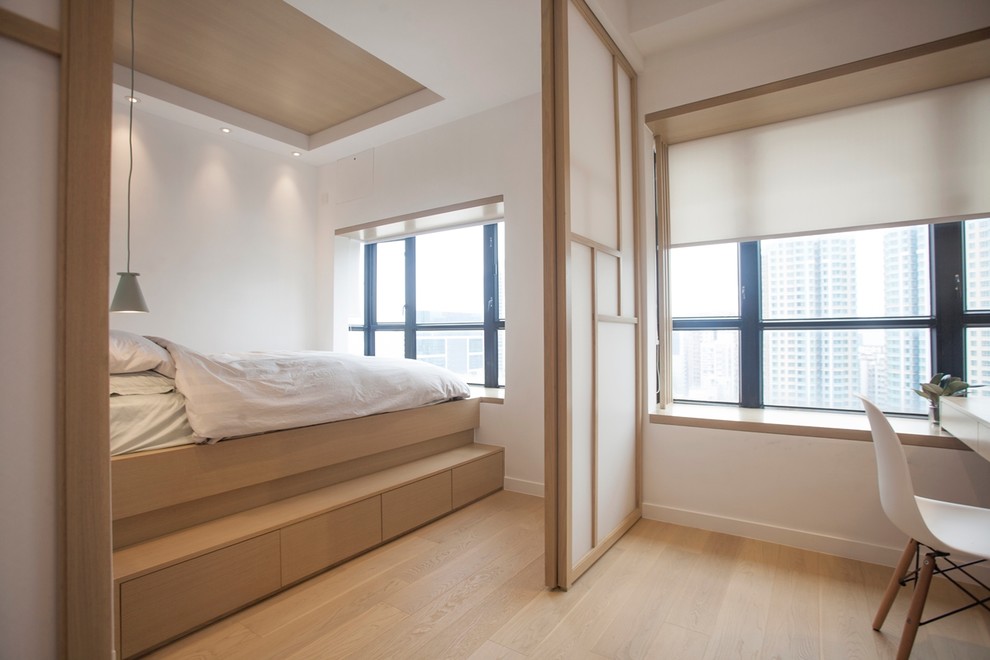 Design ideas for a mid-sized modern master bedroom in Hong Kong with white walls and light hardwood floors.