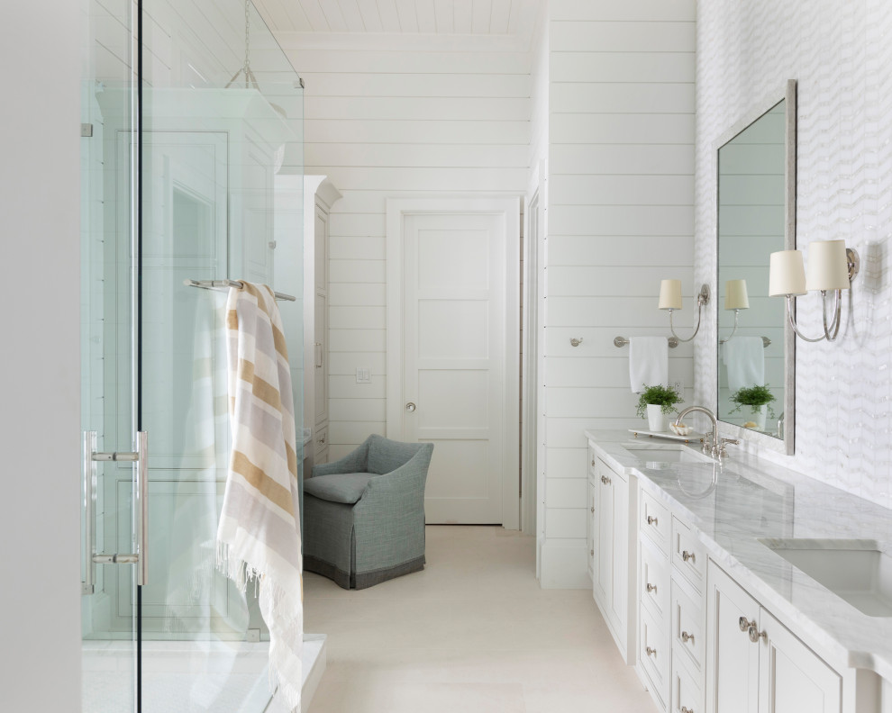 Inspiration for a large beach style master wet room bathroom in Other with recessed-panel cabinets, white cabinets, white walls, an integrated sink, marble benchtops, beige floor, a hinged shower door, white benchtops, a double vanity, a built-in vanity, timber and planked wall panelling.