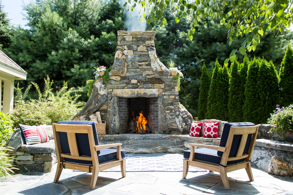 Inspiration for a large country backyard patio in New York with a fire feature, natural stone pavers and no cover.