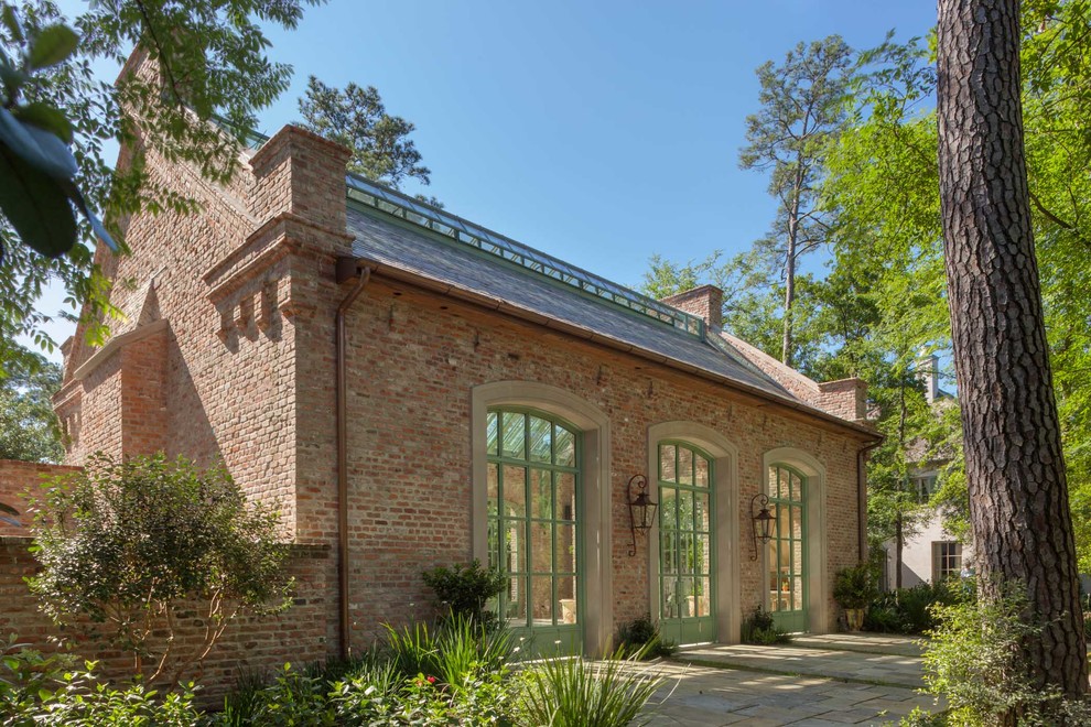 Design ideas for an expansive industrial one-storey brick red exterior in Houston with a gable roof.