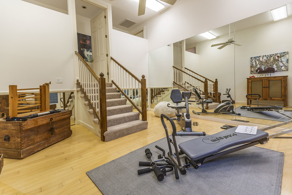 Inspiration for a large transitional multipurpose gym in Tampa with white walls, bamboo floors and beige floor.