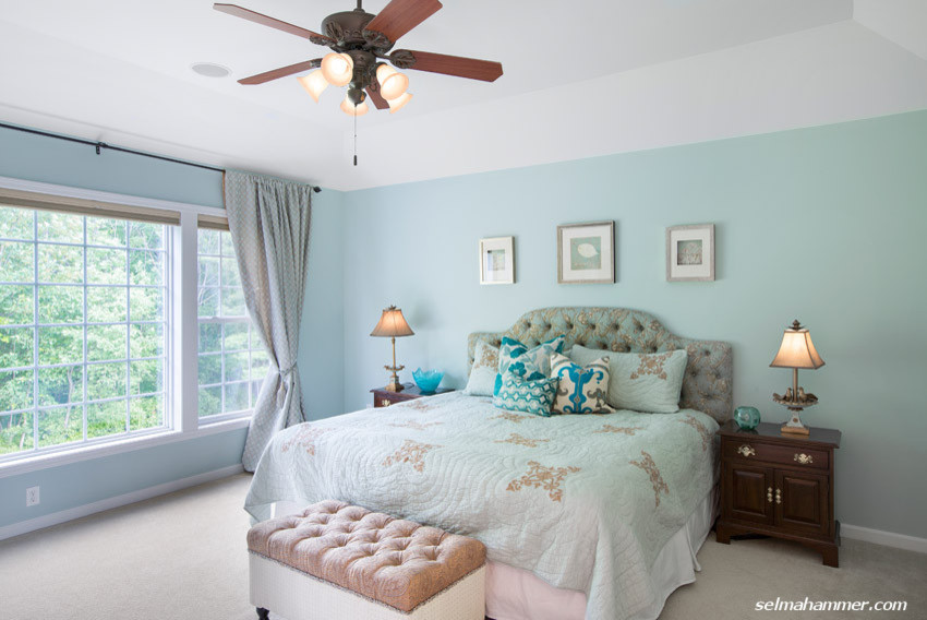 Large beach style master bedroom in New York with blue walls, carpet and no fireplace.