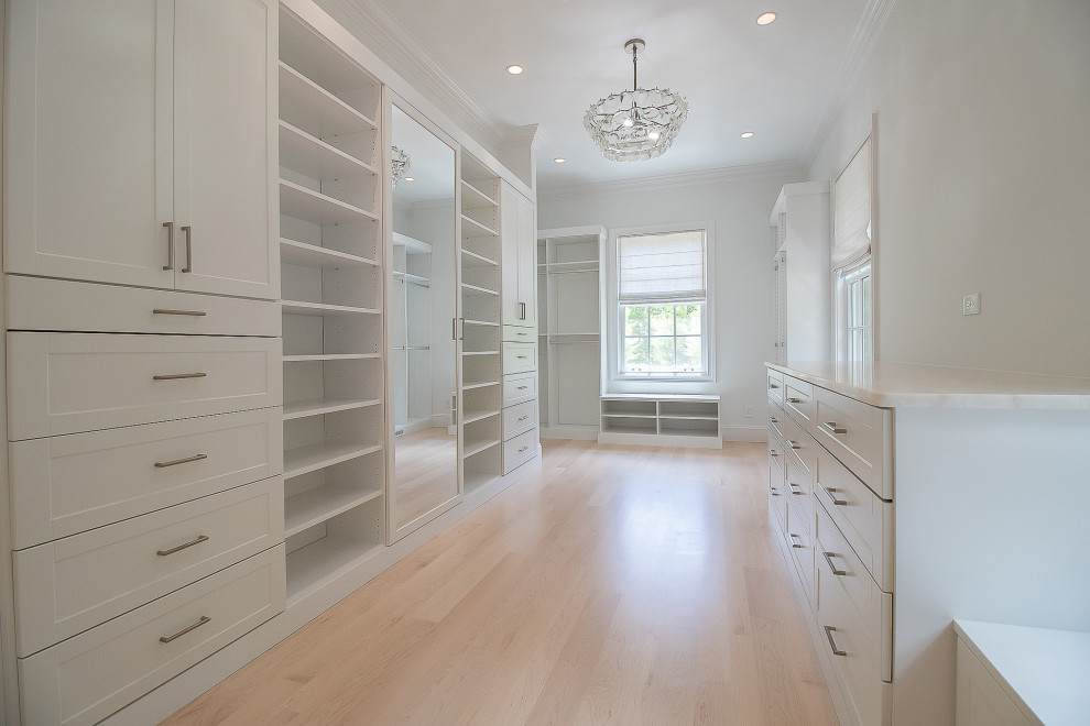 Dressing room - huge traditional gender-neutral light wood floor and brown floor dressing room idea in Cleveland with recessed-panel cabinets and white cabinets