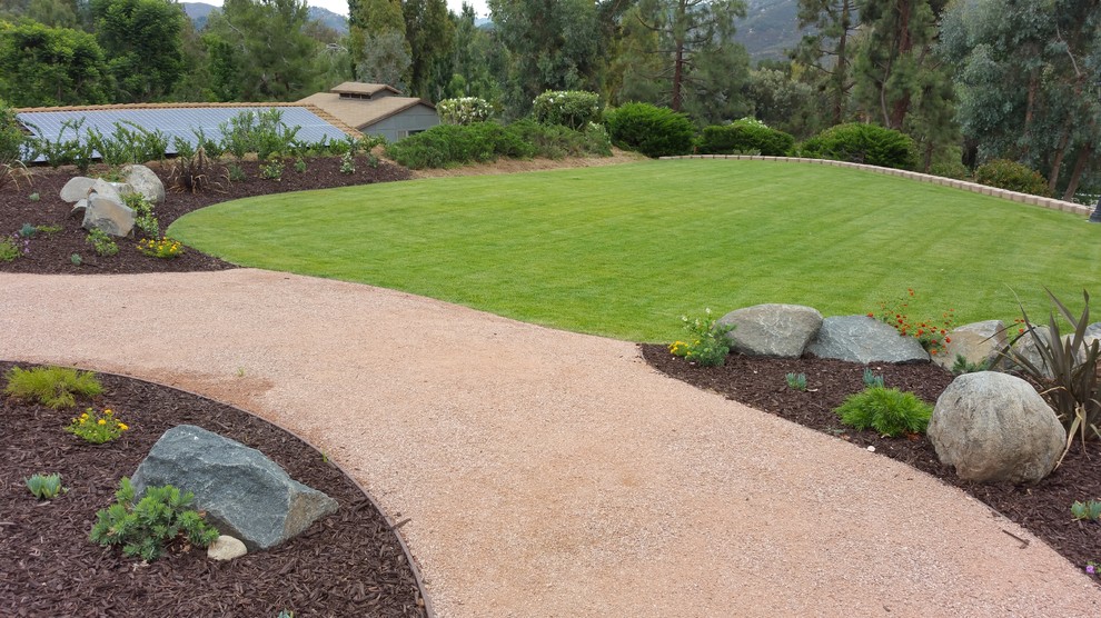 This is an example of an expansive mediterranean backyard full sun formal garden for summer in San Diego with gravel.