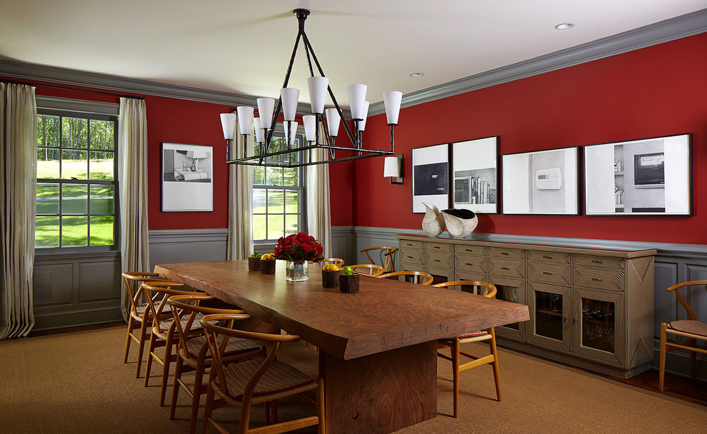 Large transitional dining room in New York with red walls and dark hardwood floors.