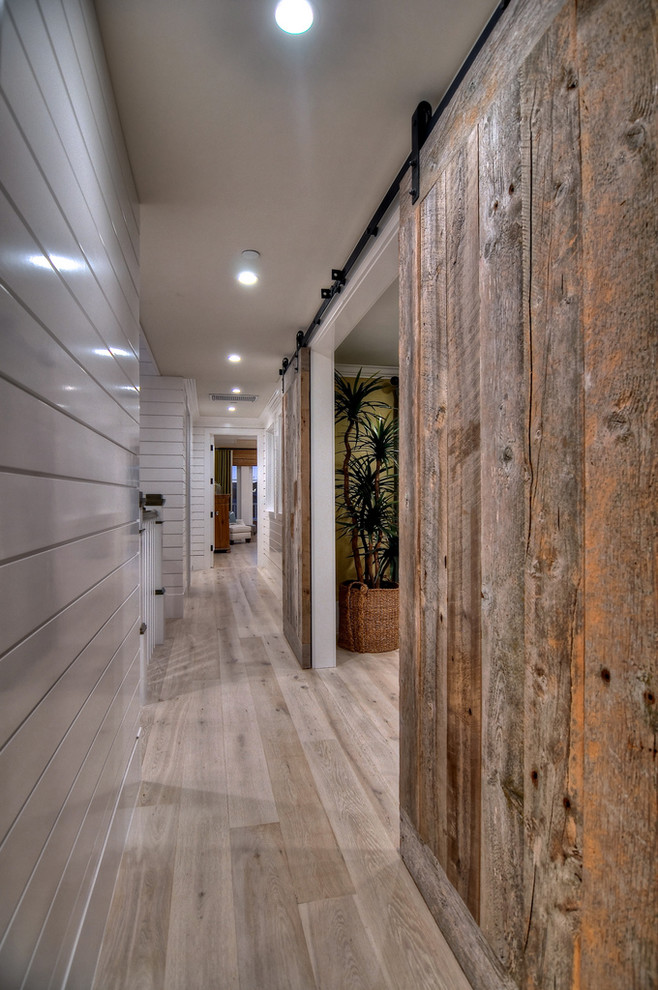 Design ideas for an eclectic hallway in Orange County with white walls and light hardwood floors.