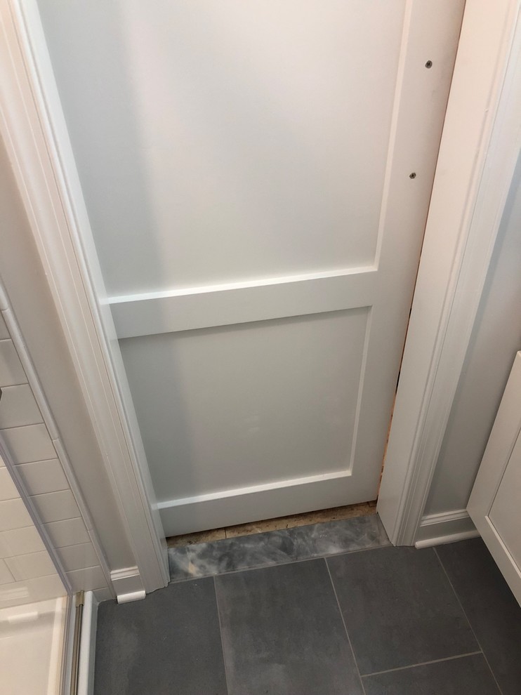 Inspiration for a small modern 3/4 bathroom in DC Metro with shaker cabinets, white cabinets, an alcove shower, a two-piece toilet, white tile, ceramic tile, white walls, porcelain floors, an undermount sink, granite benchtops, grey floor, a sliding shower screen and blue benchtops.