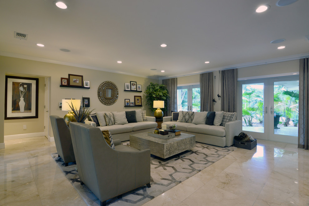 This is an example of a mid-sized contemporary enclosed family room in Miami with beige walls, marble floors, no fireplace, a built-in media wall and beige floor.