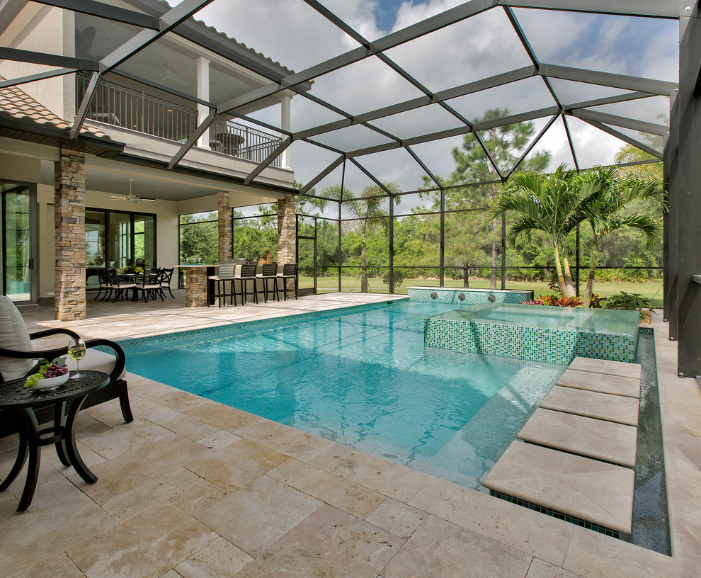 Photo of a large transitional backyard l-shaped infinity pool in Tampa with natural stone pavers and a hot tub.