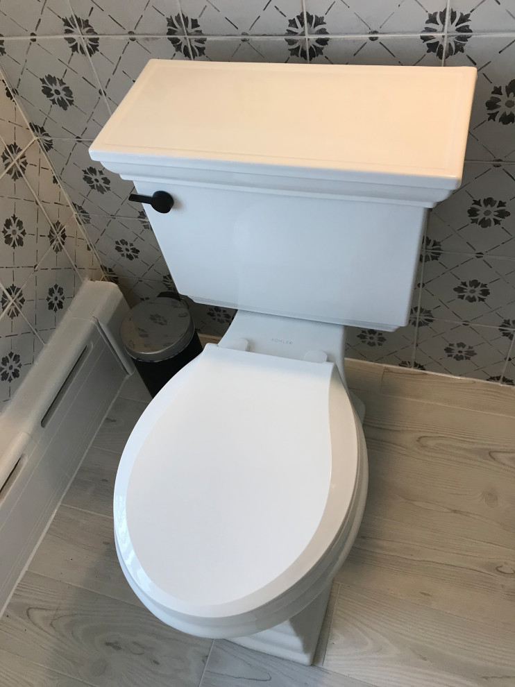 This is an example of a small traditional kids bathroom in Baltimore with an alcove tub, an alcove shower, a two-piece toilet, black and white tile, ceramic tile, grey walls, ceramic floors, a pedestal sink, grey floor, a sliding shower screen, a niche and a single vanity.