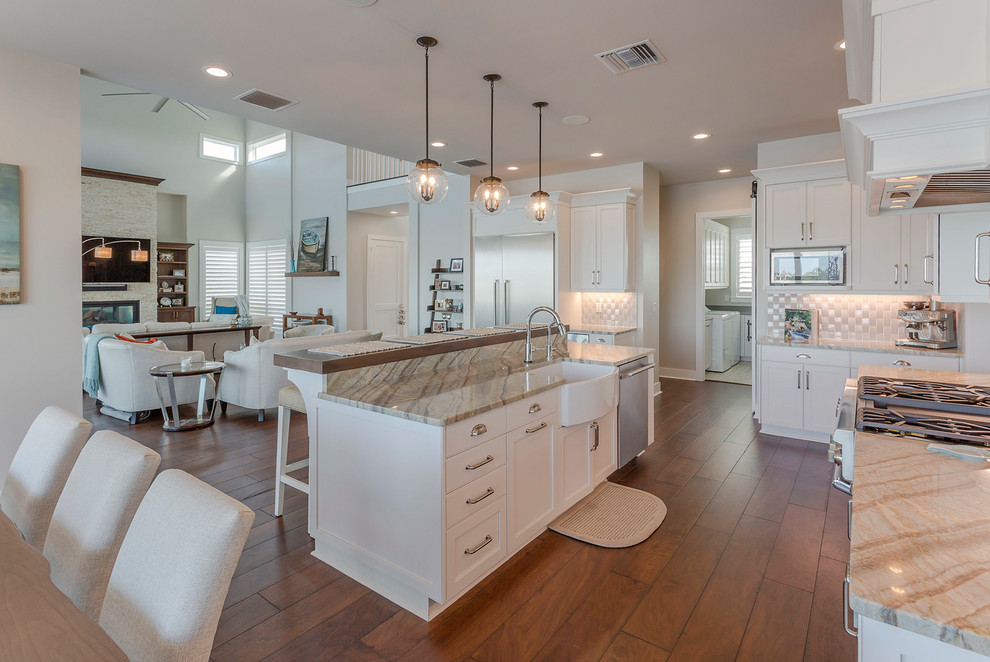 Design ideas for a large beach style galley eat-in kitchen in Tampa with a farmhouse sink, beaded inset cabinets, white cabinets, marble benchtops, multi-coloured splashback, mosaic tile splashback, dark hardwood floors, brown floor, multi-coloured benchtop, stainless steel appliances and with island.