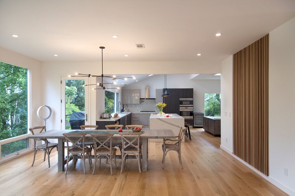Design ideas for a mid-sized contemporary open plan dining in San Francisco with white walls, light hardwood floors, no fireplace and yellow floor.