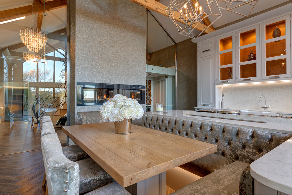 This is an example of an expansive farmhouse kitchen/diner with a belfast sink, raised-panel cabinets, vinyl flooring and an island.