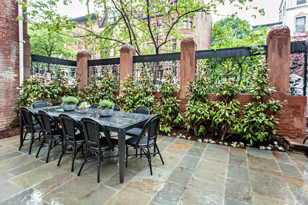 This is an example of a mid-sized transitional side yard patio in New York with a vertical garden and natural stone pavers.