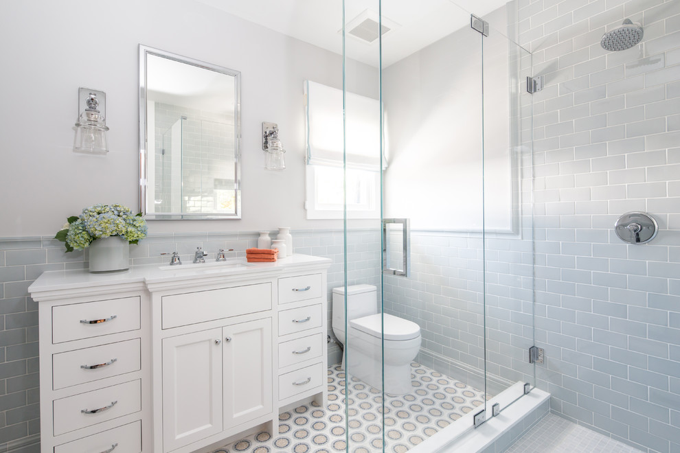 Mid-sized traditional 3/4 bathroom in Los Angeles with recessed-panel cabinets, white cabinets, a corner shower, a one-piece toilet, mosaic tile, grey walls, mosaic tile floors, an undermount sink, engineered quartz benchtops, gray tile and a hinged shower door.