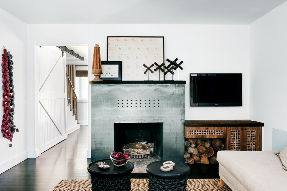Photo of an eclectic living room in San Francisco with a standard fireplace, a metal fireplace surround and a wall-mounted tv.