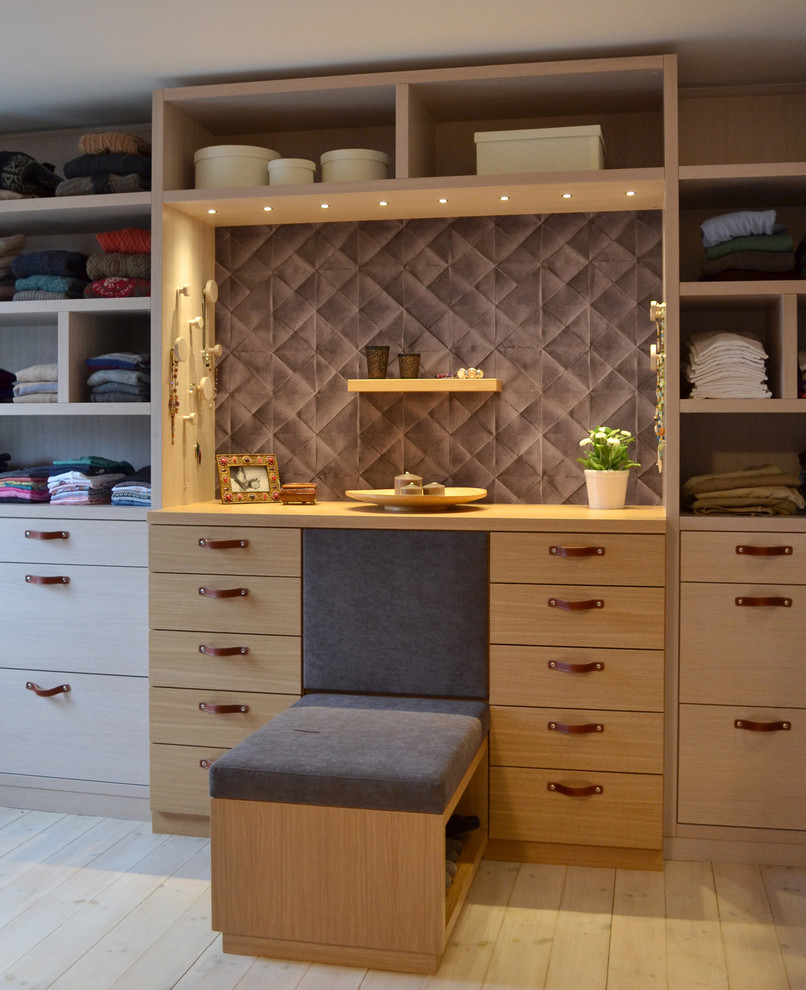 Large traditional women's dressing room in Hamburg with flat-panel cabinets, light wood cabinets and light hardwood floors.