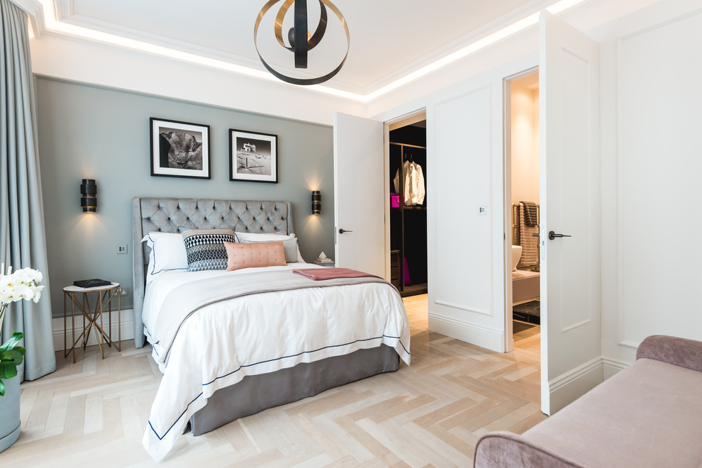 Design ideas for a mid-sized transitional master bedroom in London with white walls, light hardwood floors and beige floor.