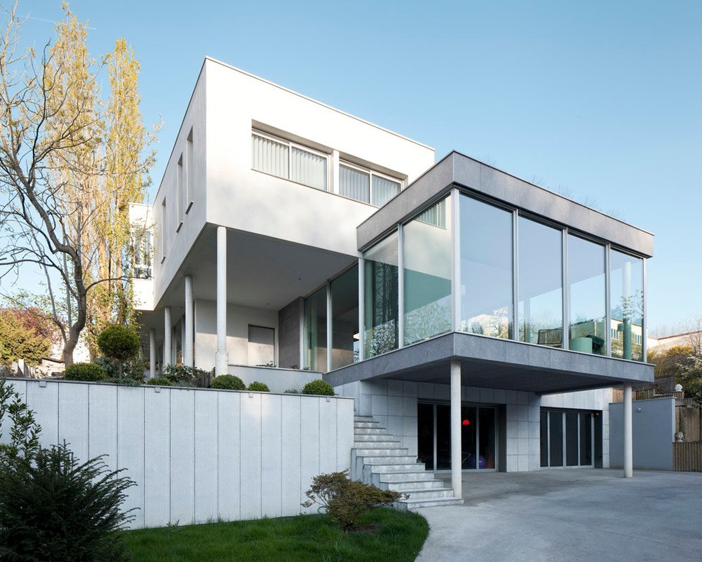 Design ideas for a mid-sized modern three-storey glass white exterior in Paris with a flat roof.