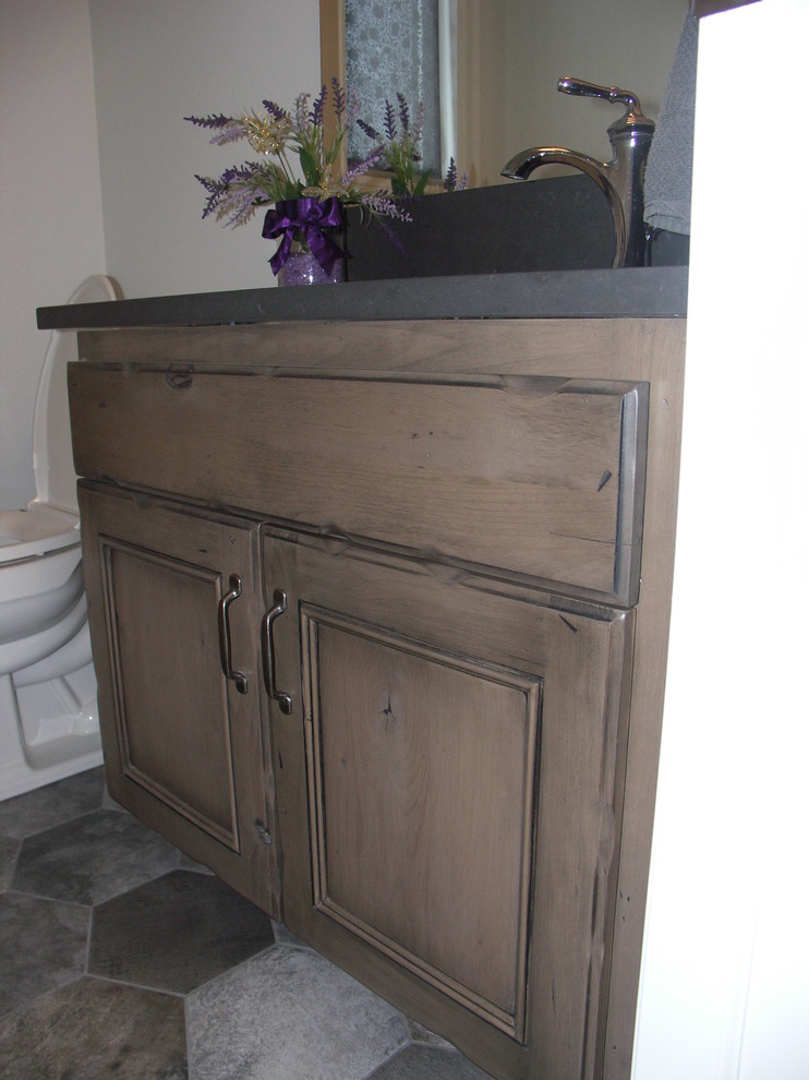 Inspiration for a transitional 3/4 bathroom in Edmonton with recessed-panel cabinets, light wood cabinets, a two-piece toilet, white walls, ceramic floors, soapstone benchtops and brown floor.