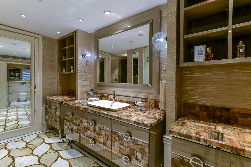 This is an example of a contemporary master bathroom in Delhi with flat-panel cabinets, brown cabinets, a one-piece toilet, brown walls, a vessel sink, multi-coloured floor and brown benchtops.