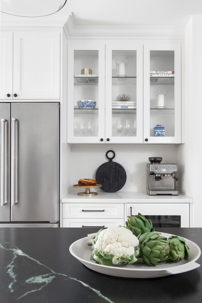 Kitchen pantry - small transitional l-shaped light wood floor and brown floor kitchen pantry idea in Toronto with a double-bowl sink, recessed-panel cabinets, white cabinets, soapstone countertops, white backsplash, porcelain backsplash, stainless steel appliances, an island and black countertops
