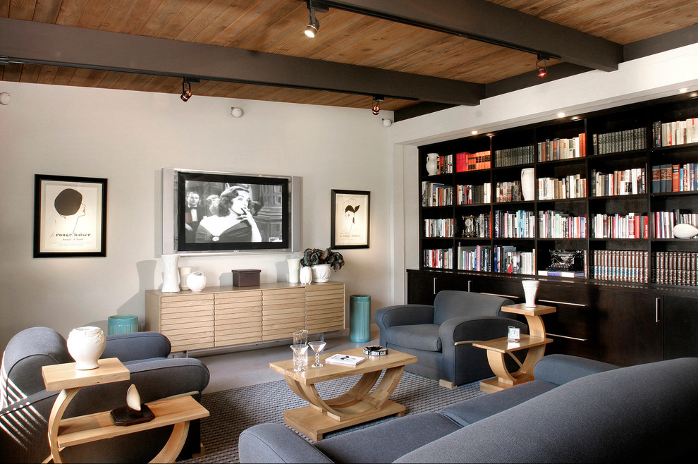 This is an example of a midcentury family room in Los Angeles with a library, white walls and a wall-mounted tv.