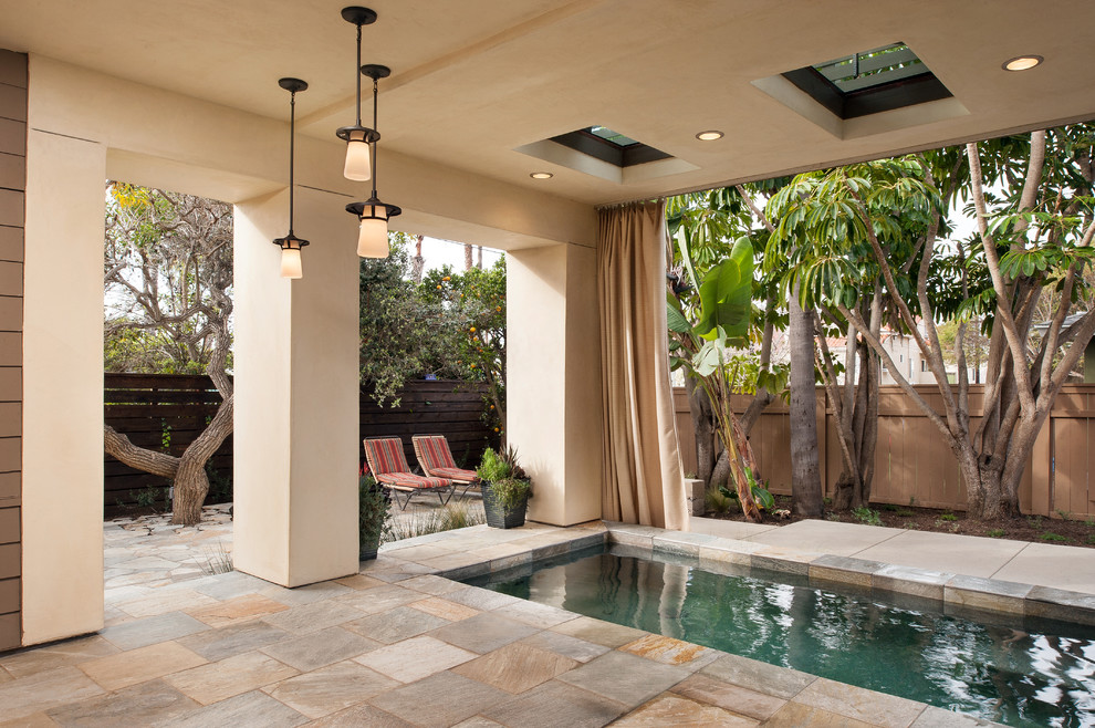 Inspiration for a large transitional backyard rectangular pool in San Diego with natural stone pavers.
