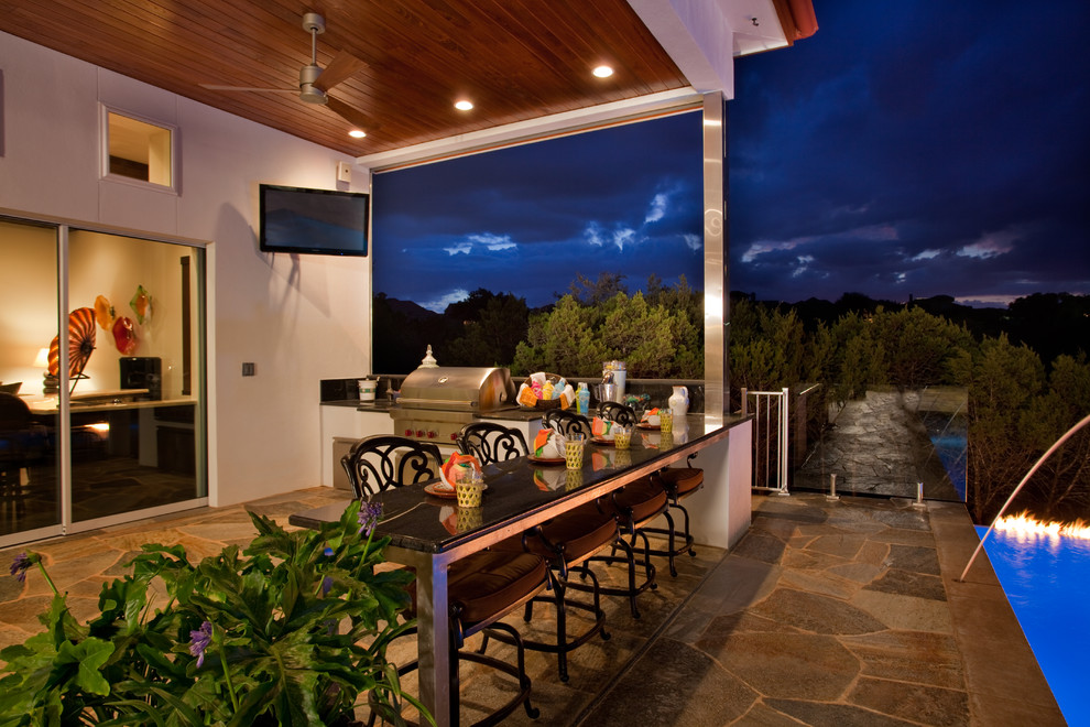 Example of a mid-sized mountain style backyard stone and rectangular infinity pool design in Austin