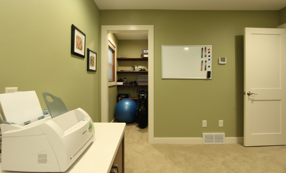 Photo of a mid-sized transitional home office in Other with green walls, carpet, a built-in desk and beige floor.