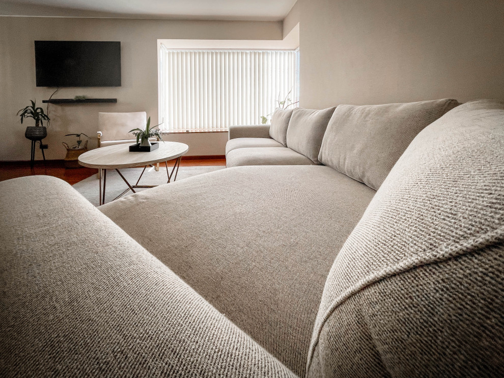 Immagine di un grande soggiorno design con pareti beige, pavimento in laminato, TV a parete, pavimento marrone, carta da parati e tappeto