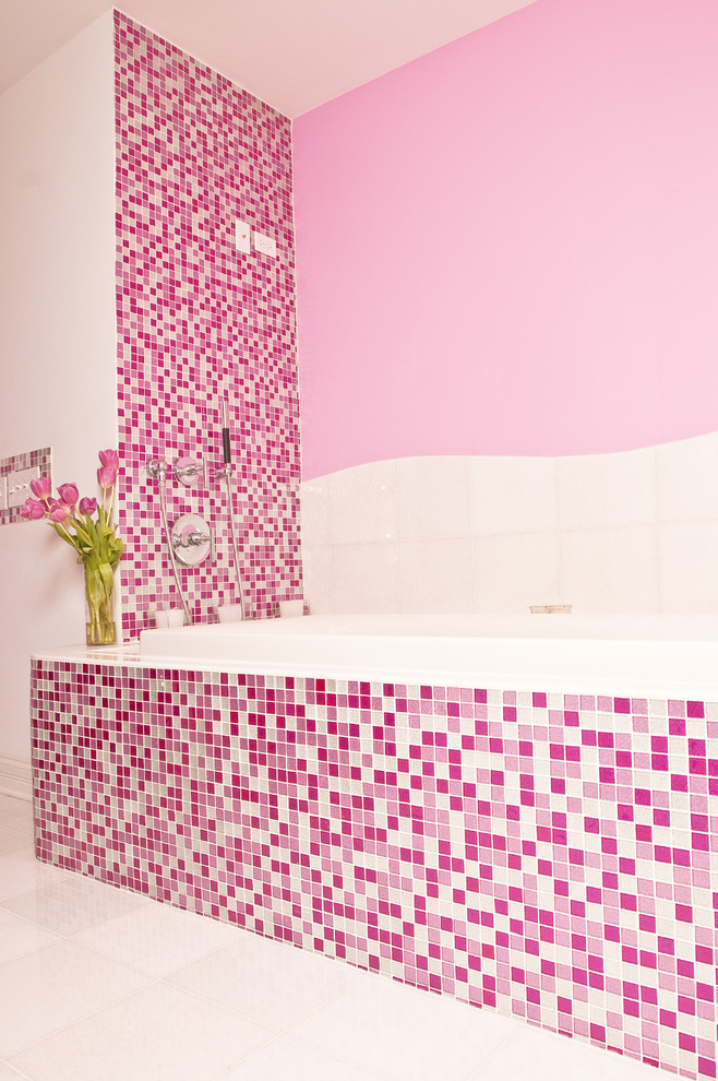 Photo of a large contemporary bathroom in New York with open cabinets, a drop-in tub, a one-piece toilet, pink tile, mosaic tile, pink walls, ceramic floors, a wall-mount sink, glass benchtops, white floor and a corner shower.
