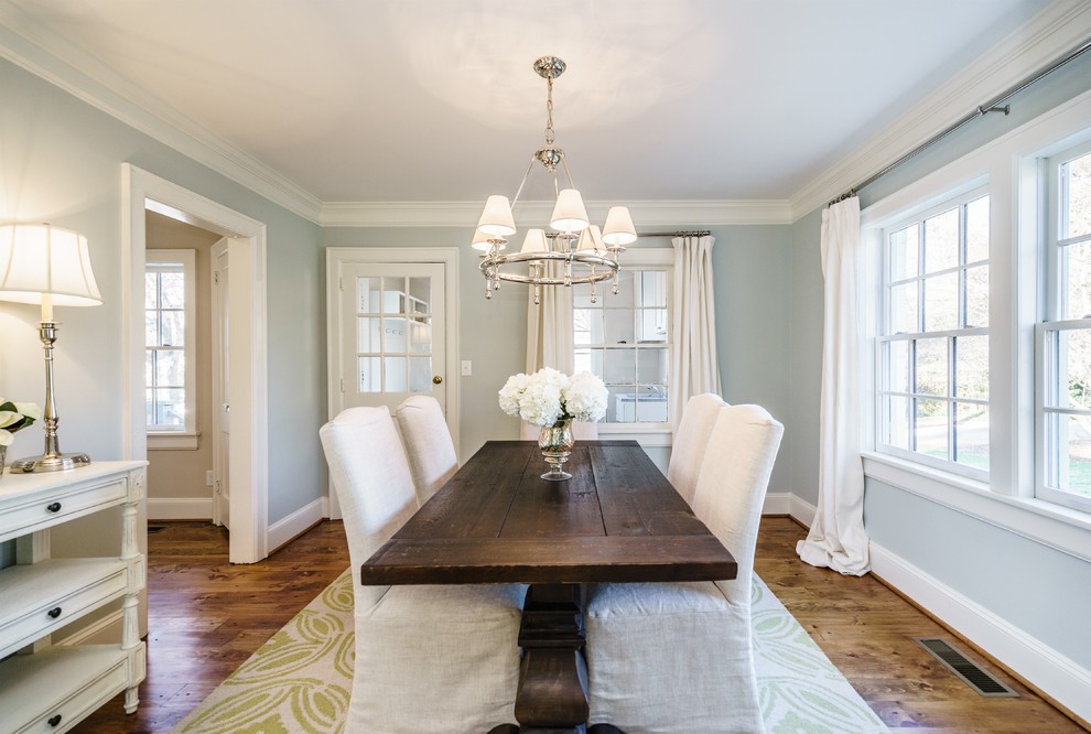 Mid-sized elegant medium tone wood floor enclosed dining room photo in Raleigh with blue walls