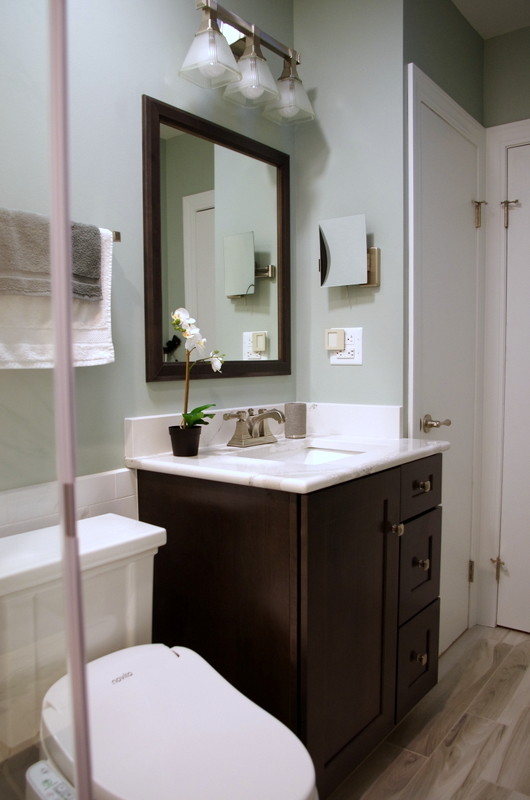 Small transitional master gray tile and porcelain tile porcelain tile and brown floor alcove shower photo in Chicago with shaker cabinets, dark wood cabinets, a one-piece toilet, gray walls, an undermount sink and quartz countertops