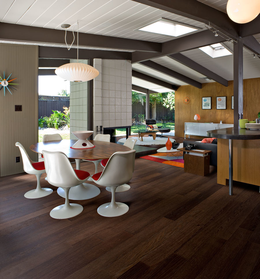 Photo of a mid-sized midcentury open plan dining in Chicago with multi-coloured walls and dark hardwood floors.